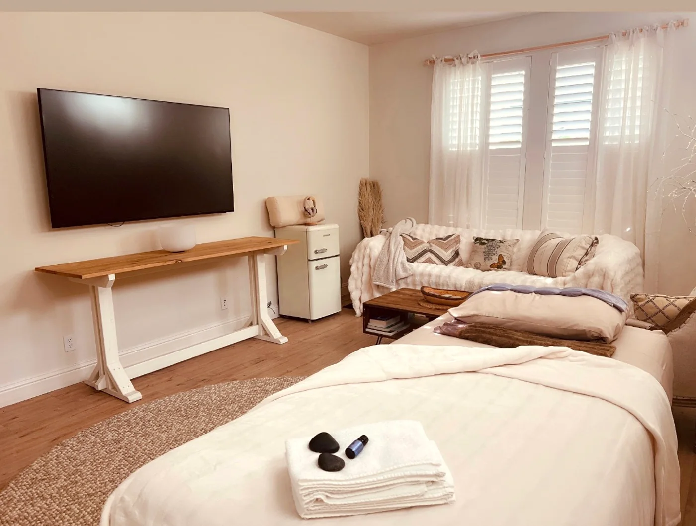 The Sanctuary treatment room with a massage table, soft linens and natural light