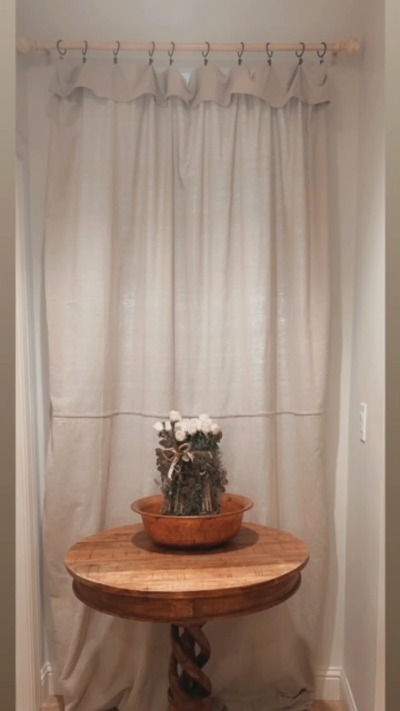 The private entrance with linen curtains and a small wooden table